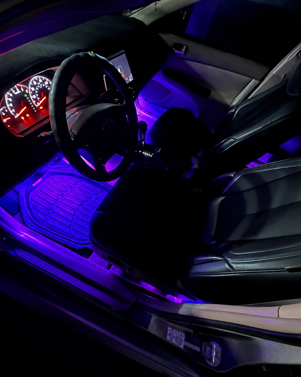 Purple footwell lighting viewed through the open driver door