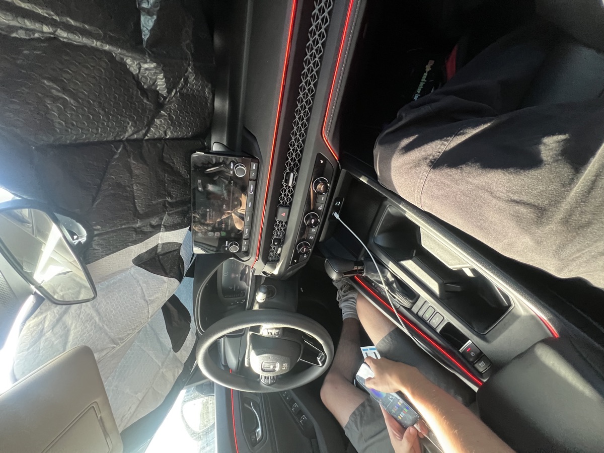 Reassembled Honda interior with red ambient lighting and phone controls in use