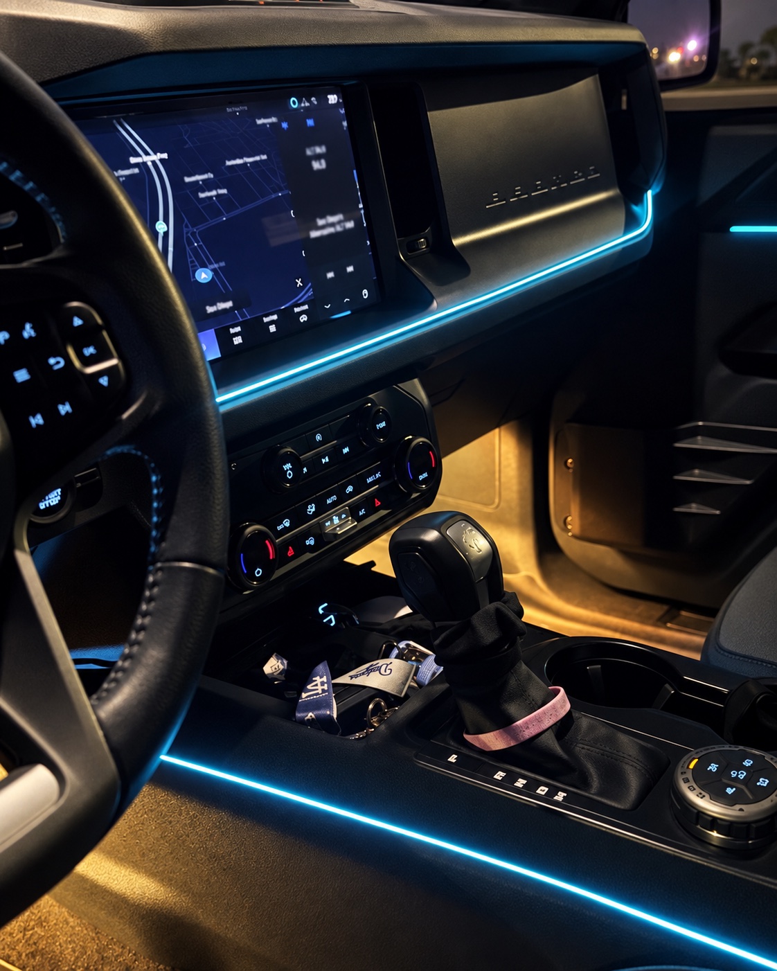 Cyan lighting across the dashboard and along the console with warm amber footwell illumination